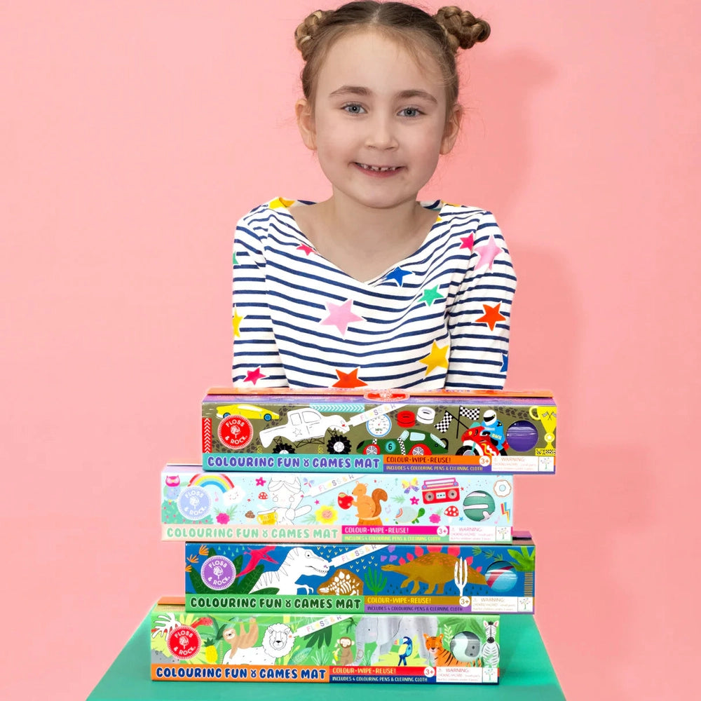 Floss and Rock Colouring Fun and Games Mat set of five colorful boxes held by a smiling girl in a striped shirt.