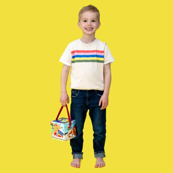 Floss and Rock Stacking Cubes: colorful building toy carried by a smiling child in a white striped tee, yellow background.