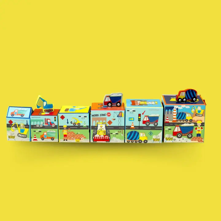 Floss and Rock Stacking Cubes, colorful vehicle-printed blocks stacked in a row with tiny cars on top.