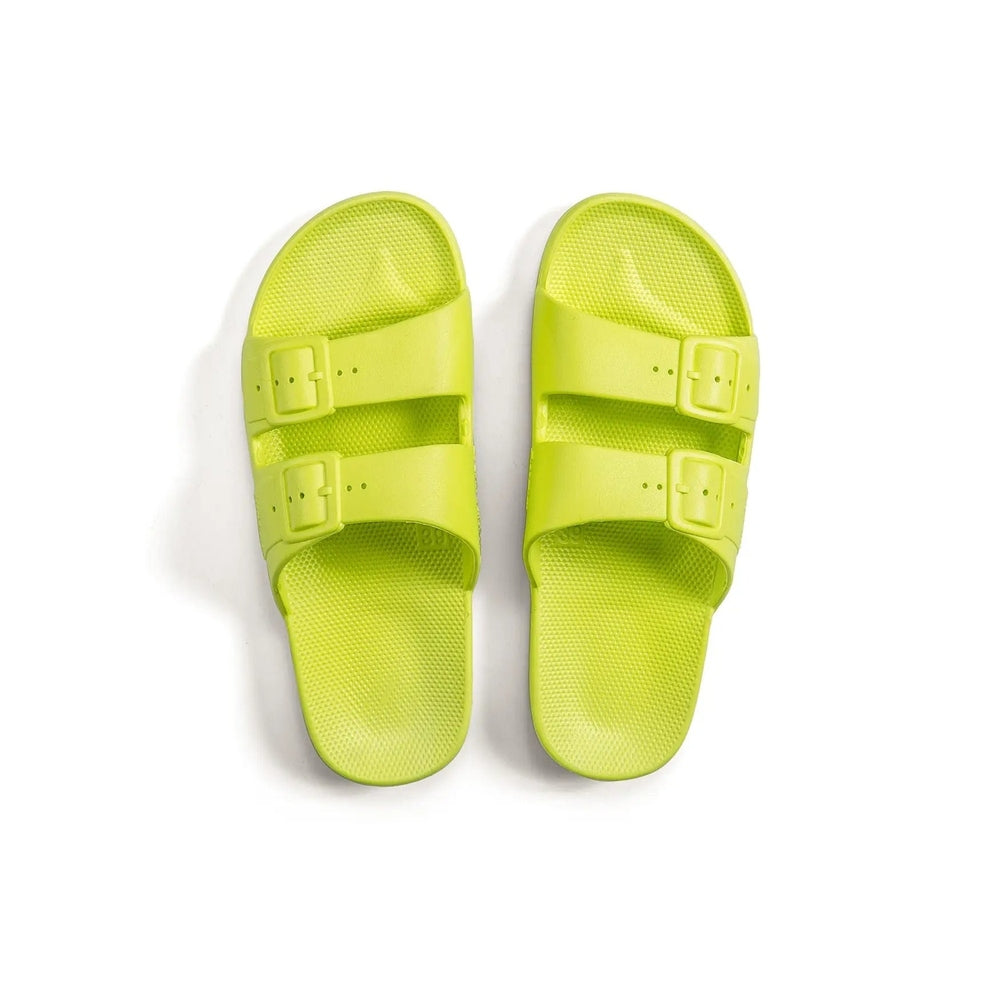 Freedom Moses Basic Alice Yellow Neon sandals with two buckle straps laid flat on a clean white backdrop