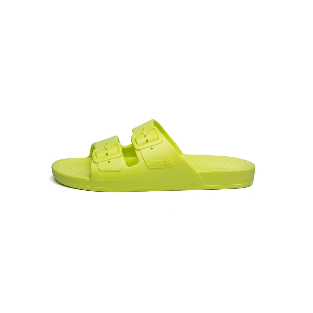 Freedom Moses Basic Alice Neon Yellow slides with two buckle straps, feet resting on the textured footbed.
