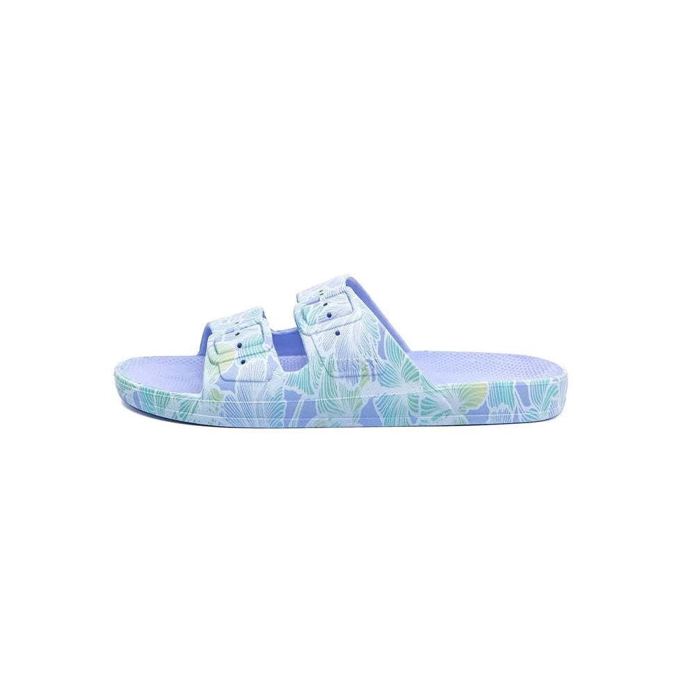 Freedom Moses Prints Aloha Hydra lavender tropical floral slides, two-strap sandals resting on a plain surface.