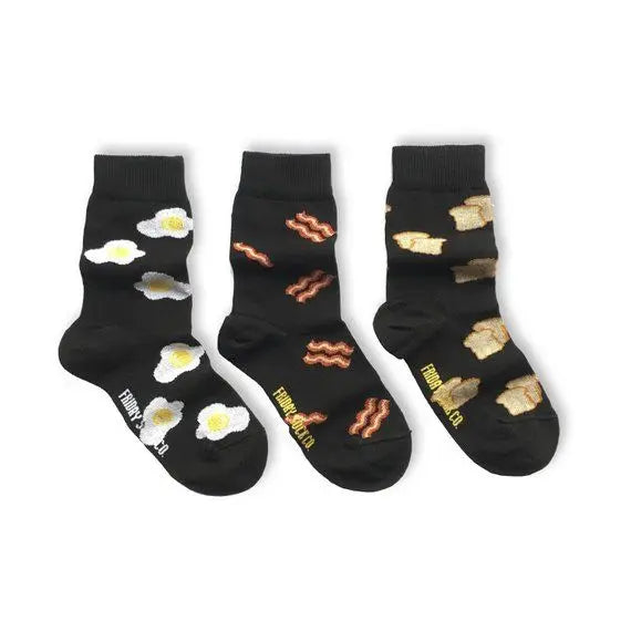 Friday Sock Co. Kid's Socks Bacon, Egg & Toast set of 3 black socks displayed with eggs, bacon and toast patterns.