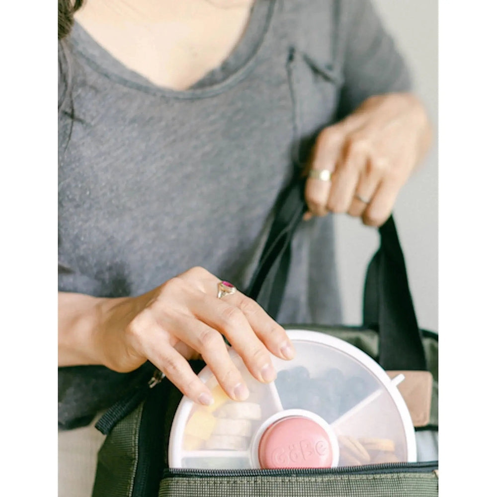 Gobe Snack Spinner Small grey lunch tote being placed into a bag, pink center visible.
