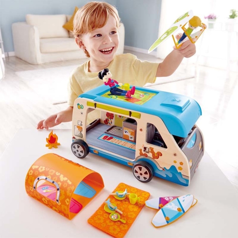 Hape Adventure Van wooden toy set in blue and beige with colorful accessories and a smiling child.