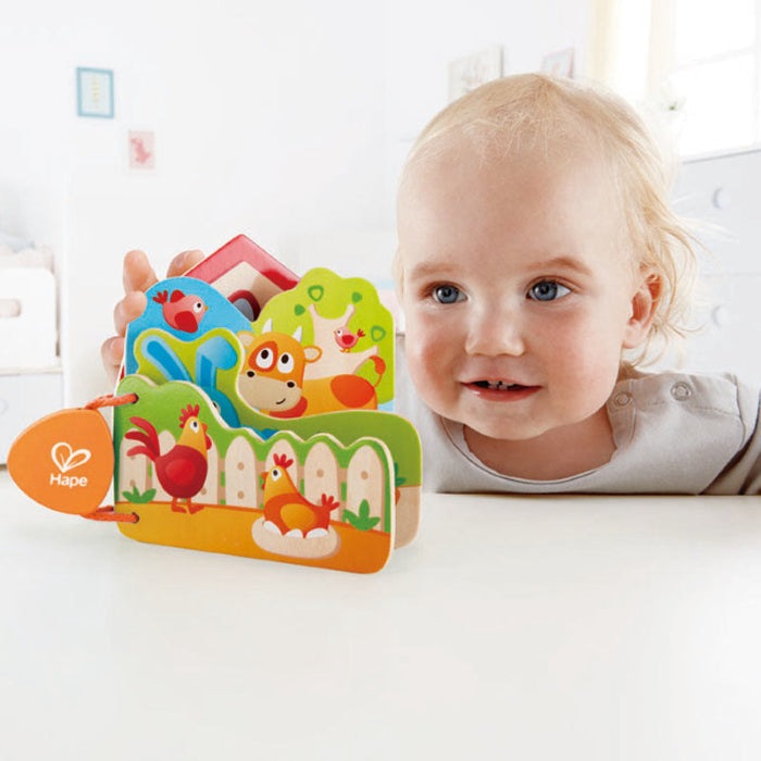 Hape Baby's Farm Animal Book wooden farm-puzzle; toddler flips colorful animal panels happily.