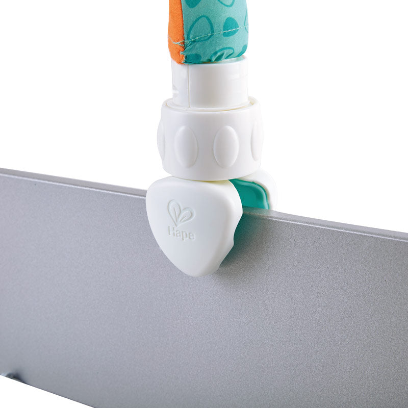 Hape Garden Friends Play Arch clamp with teal fabric strap attached to a gray surface edge