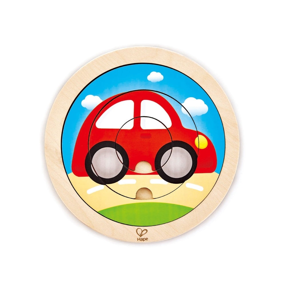 Hape Spinning Transport Puzzle round wooden puzzle with a red car on a sunny blue sky background