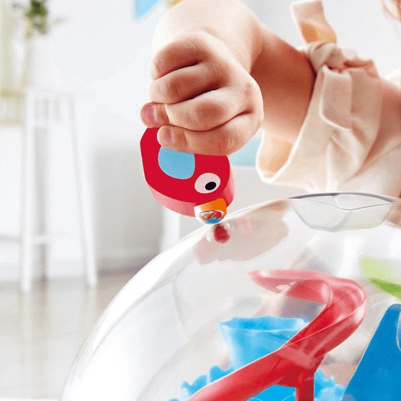 Hape Sunny Valley Adventure Dome toy; red animal figure placing a marble into the clear dome