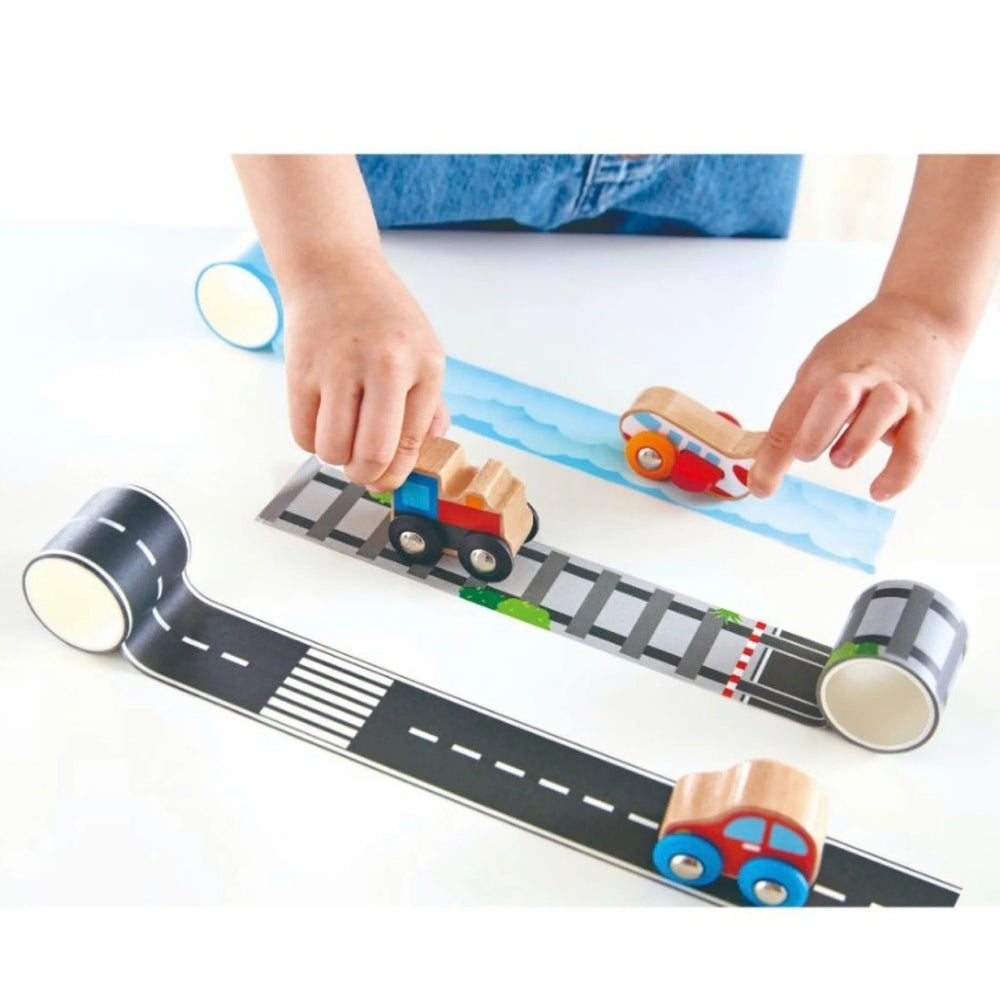 Hape Tape & Roll Train set: wooden trains roll along road-print tracks as a child guides them.