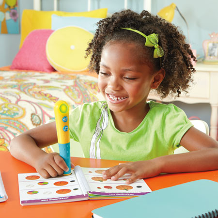 Hot Dots Jr. Master Grade 1 Math activity kit; girl uses a yellow-blue learning pen.
