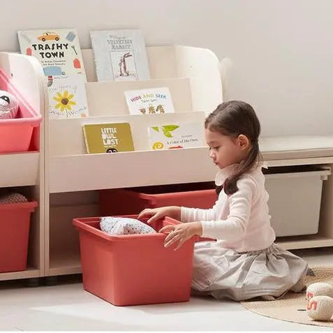 Iloom Eddi Kids Bookshelf in white with red bins; child organizes books in cozy reading nook.