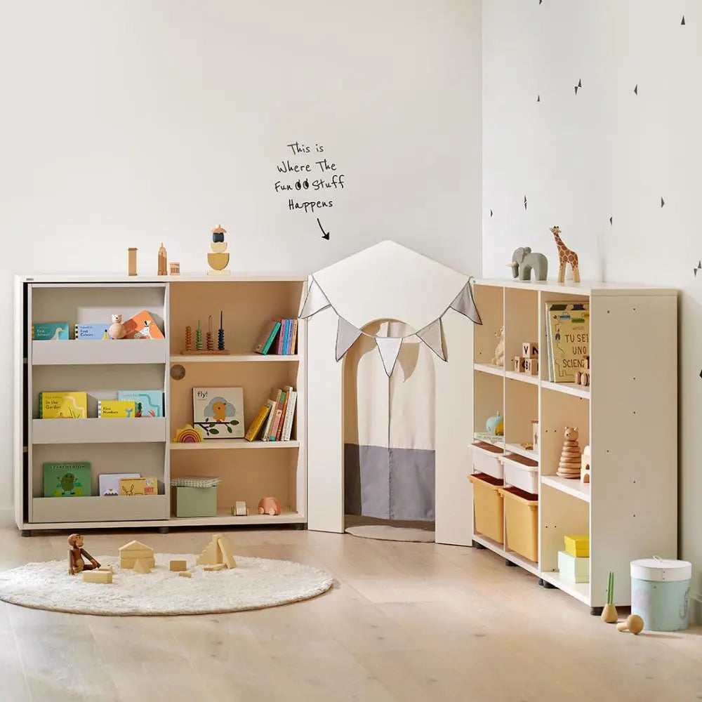 ILOOM Eddi Kids Reading House corner unit with light wood shelves and fabric curtain tent, forming a cozy reading nook.