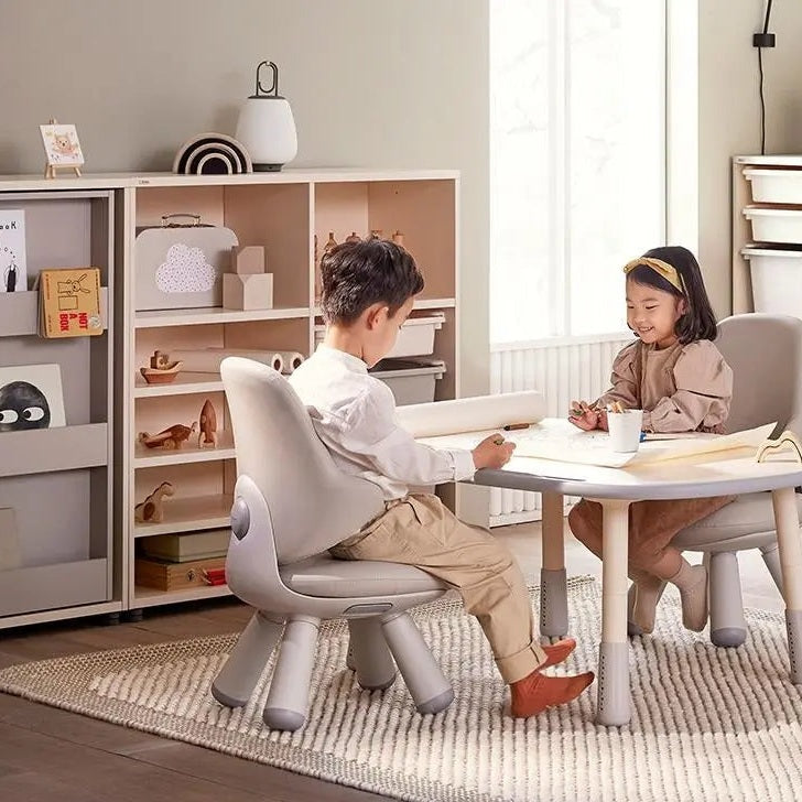 Iloom Growing Desk Rectangular 1200W; two gray kid chairs at an oval activity table in a cozy playroom.