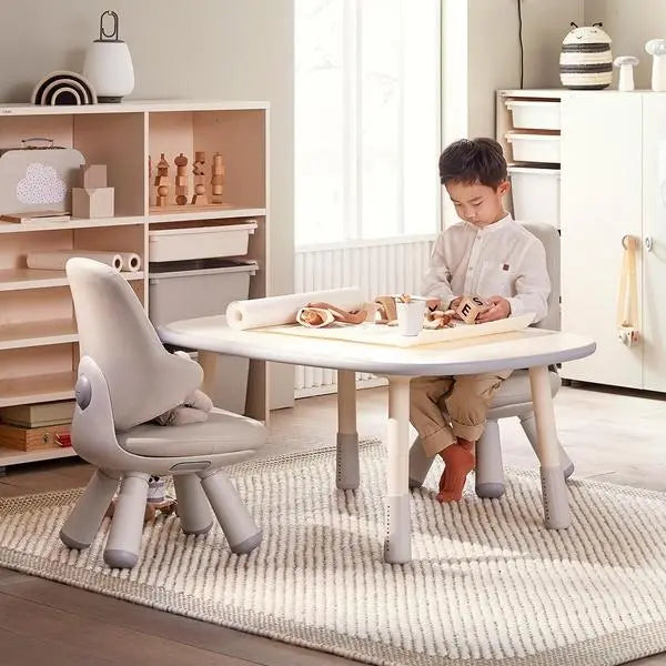 Iloom Growing Desk Rectangular 1200W activity table in light wood with matching chairs; a child sketches at the table.