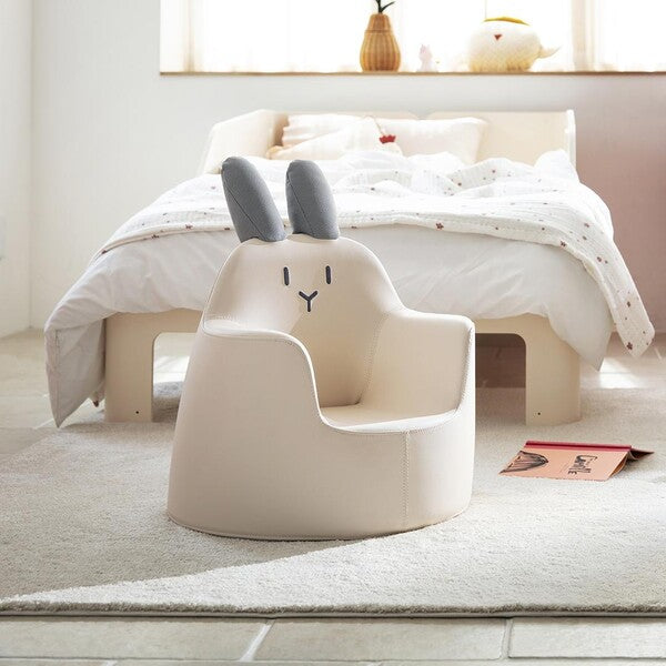 ILoom Kid's Sofa Bunny Aco Ivory: ivory faux-leather toddler sofa with gray bunny ears in a cozy bedroom.