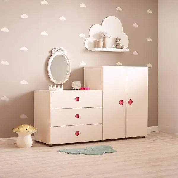 Iloom Tinkle Pop 3 Drawer Dresser 800W in white with pink knobs, shown beside a white wardrobe in a cloud nursery.