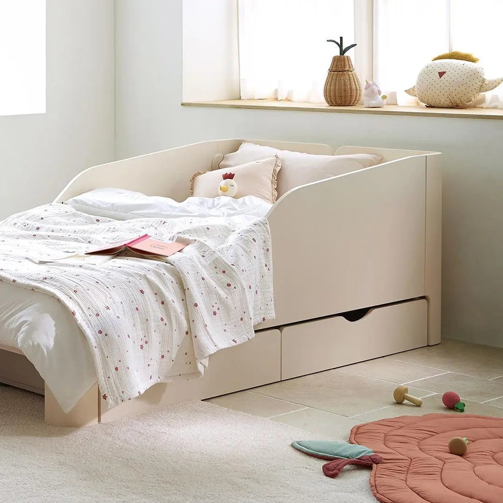 ILOOM Tinkle Pop Bed Drawer in cream with built-in under-bed drawers and white linens, creating a cozy toddler space.