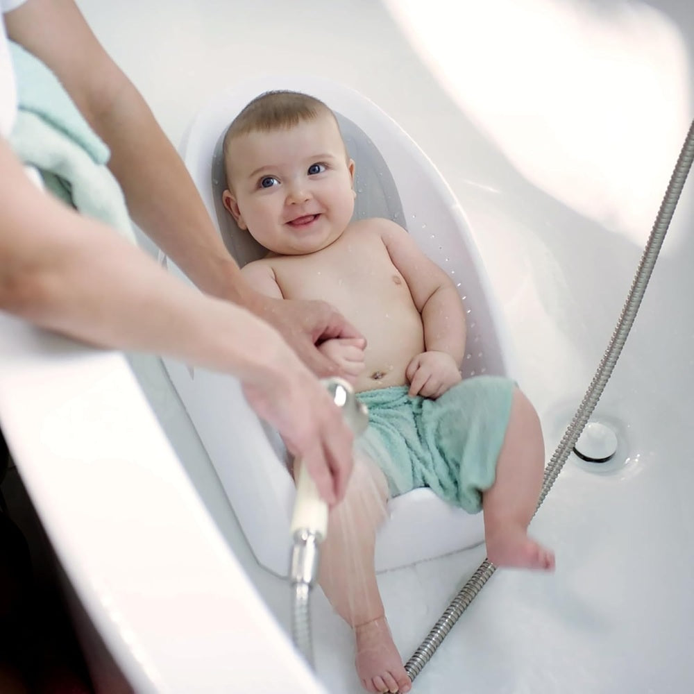 Ity by Ingenuity Easy Rinse Bather baby bath seat in tub with smiling infant during bath