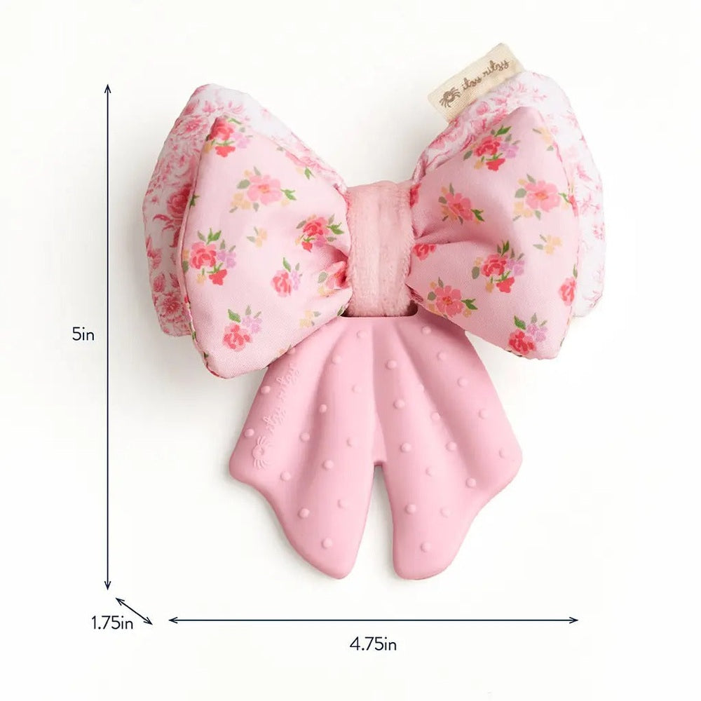 Itzy Ritzy Bow Sweetie Crinkle teething toy, pink floral bow with textured dotted silicone tails shown as a baby-friendly accessory.