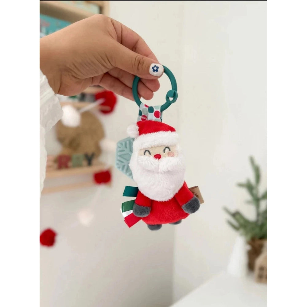 Itzy Ritzy Holiday Itzy Pal Plush Teether: Santa plush with teal ring gripped by hand.
