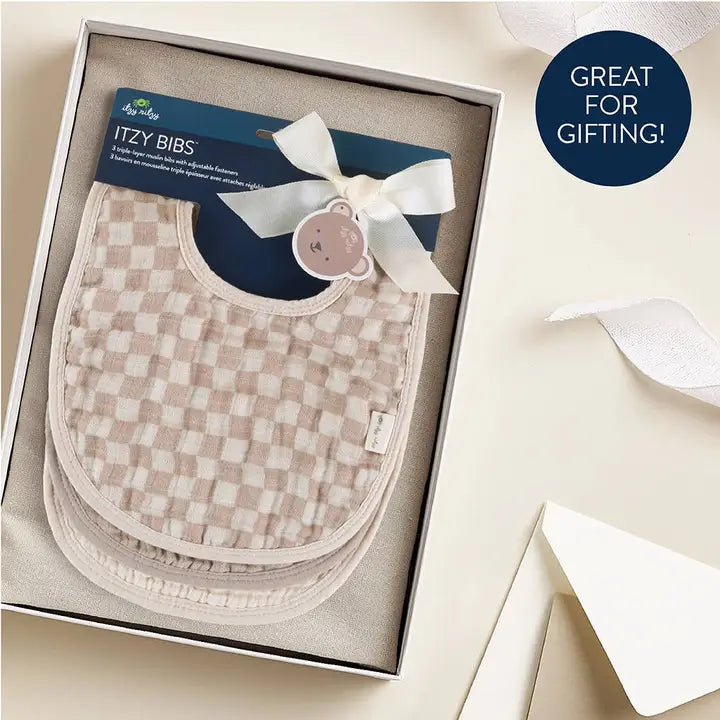 Itzy Ritzy Itzy Bibs set of 2 beige checkered bibs shown in gift box with white ribbon.