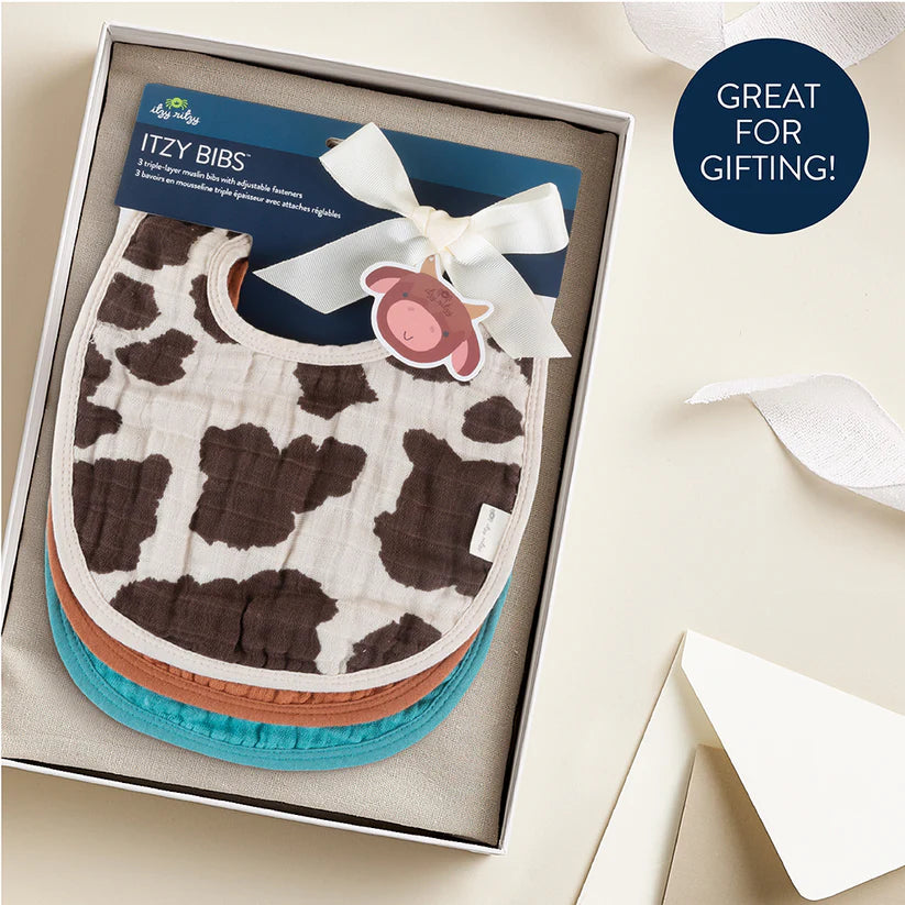 Itzy Ritzy Itzy Bibs set with cow-print front and teal, brown, orange backs in gift box.