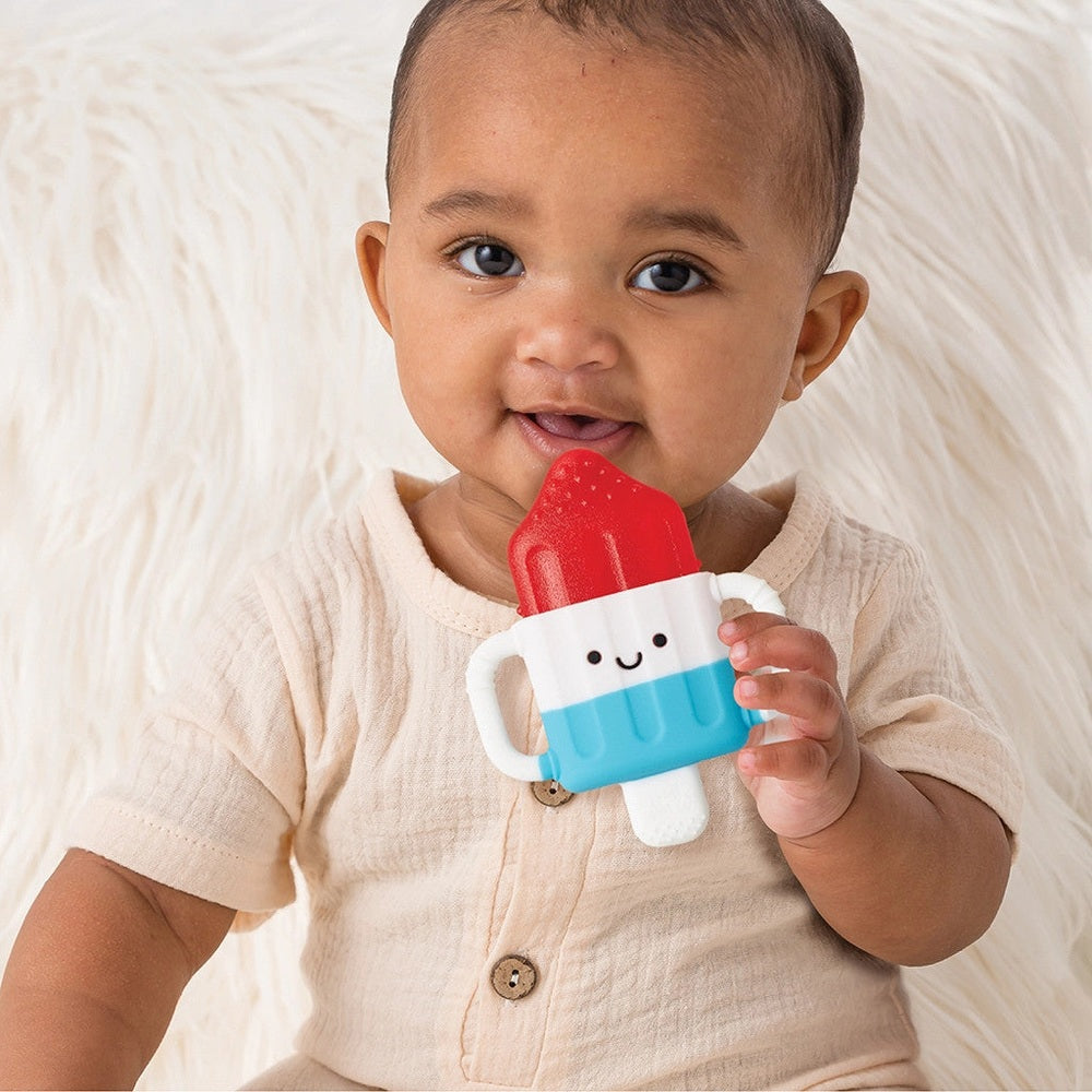 Teething toy popsicle by ITZY RITZY in red, white and blue with a smiling face.