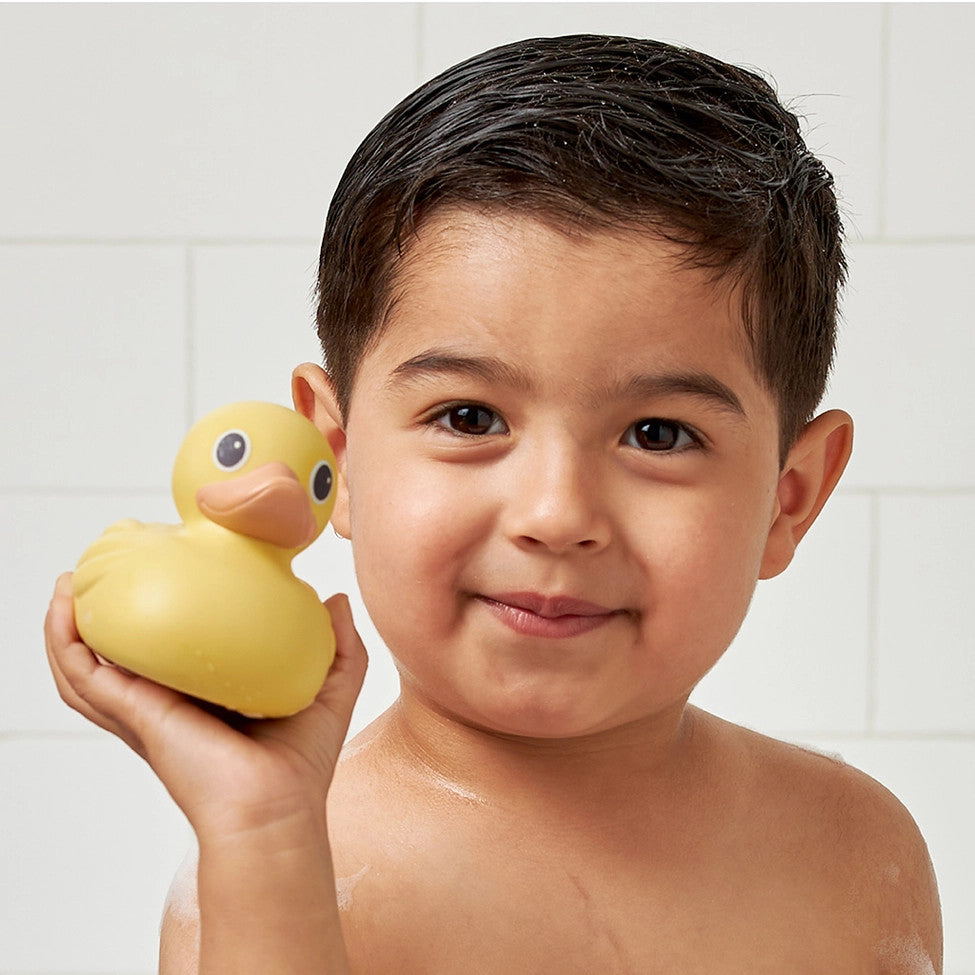 Itzy Ritzy Itzy Ducky Family bath toy; yellow rubber duck held by smiling child