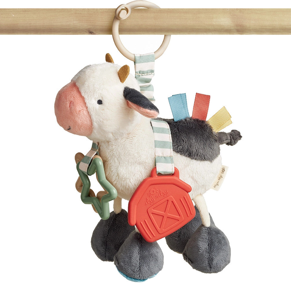 Itzy Ritzy Itzy Friends Link & Love activity plush cow with hanging ring and colorful ribbons