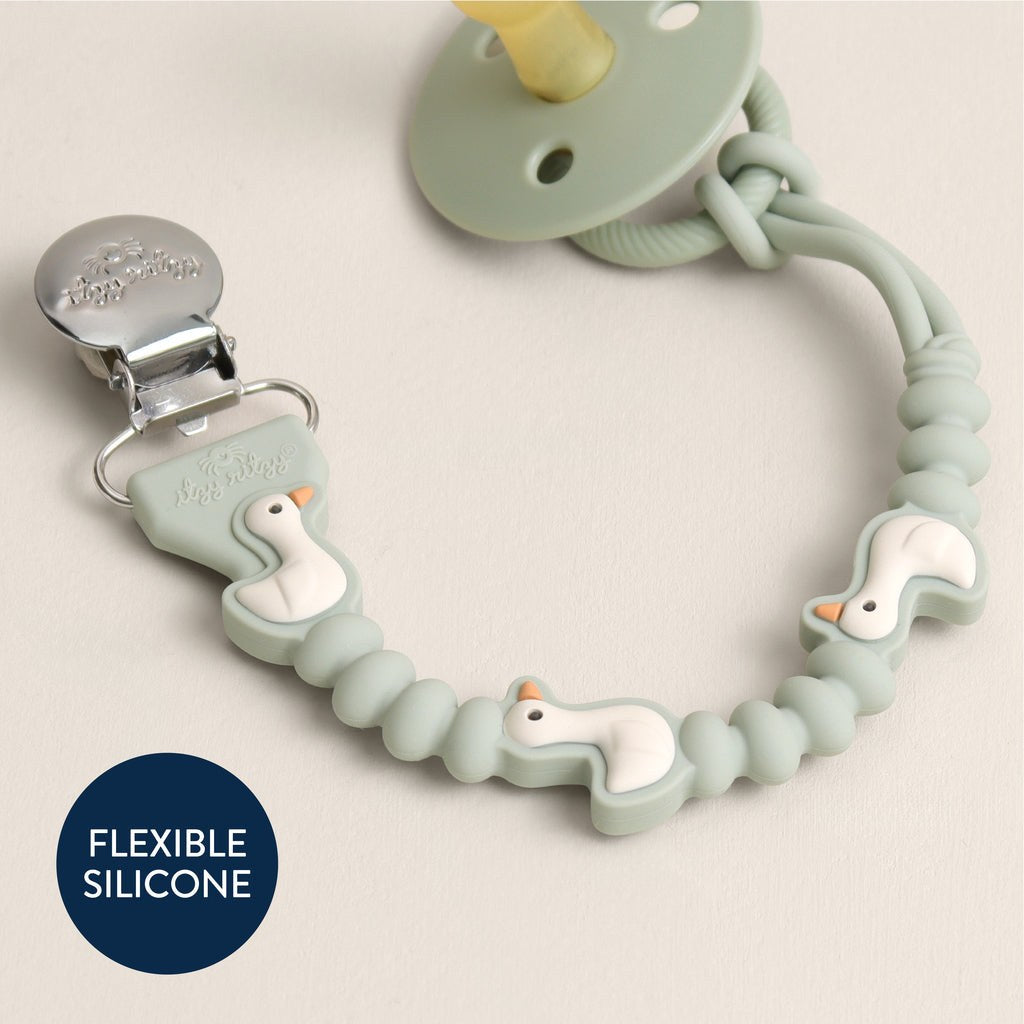 Close-up of the flexible sage silicone Goose strap, metal clip and pacifier attachment