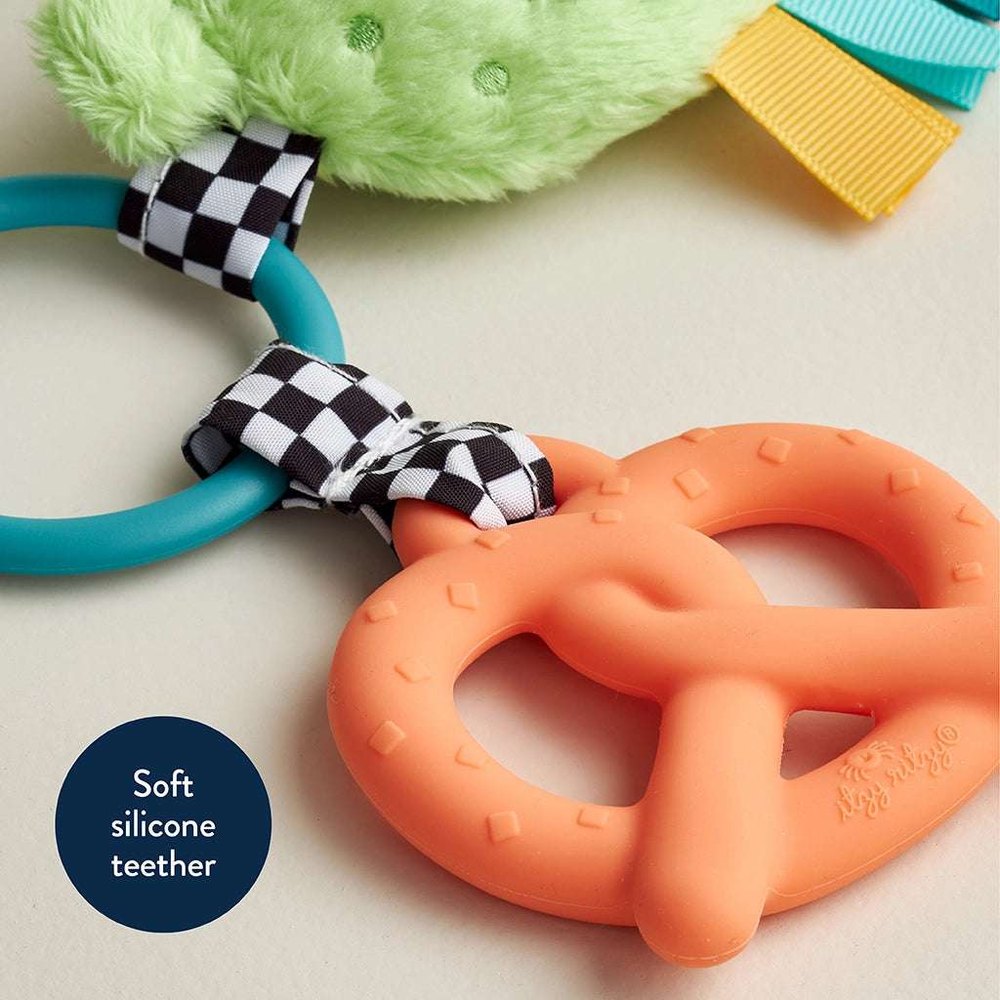 Itzy Ritzy Itzy Pal Parker The Pickle teether; orange silicone pickle with teal ring and checkered ribbon accents.