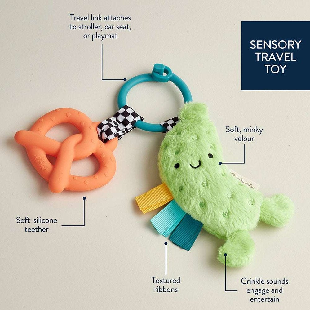 Itzy Ritzy Itzy Pal Parker The Pickle teether with orange silicone ring, teal ring, and soft plush pickle with ribbons