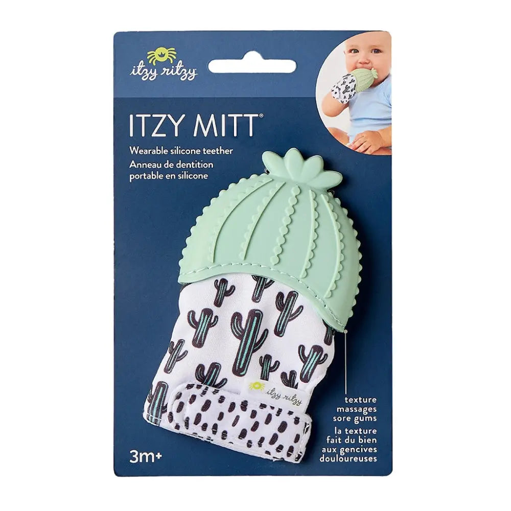 Itzy Ritzy Itzy Silicone Teething Mitts mint green cactus teether worn on baby's hand with cactus-pattern fabric.