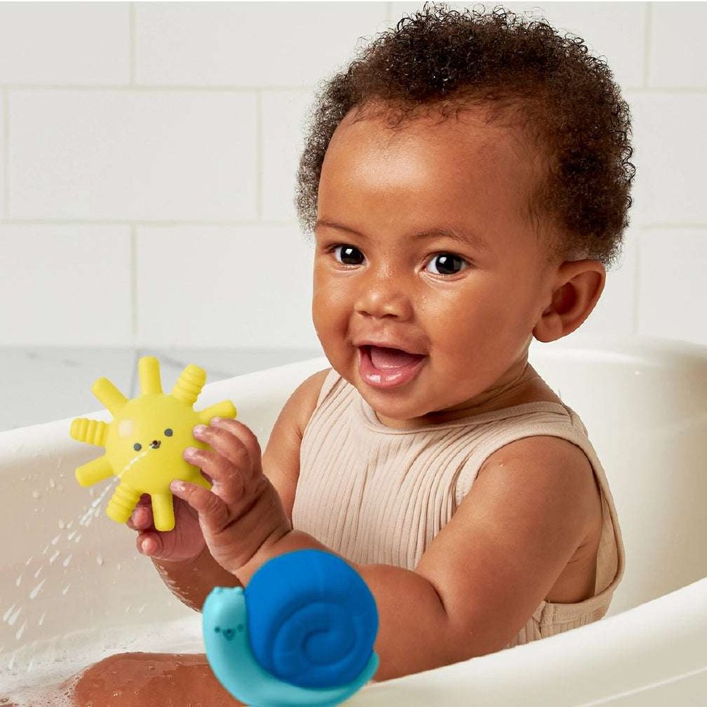 Itzy Ritzy Itzy Splash Bath Toys Gift Set; baby in tub playing with two toys: yellow sun and blue snail