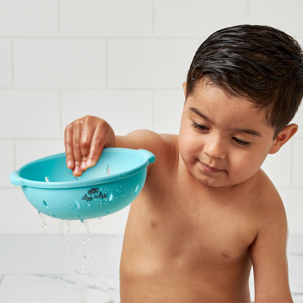 Itzy Ritzy Itzy Splash Pals bath toy in turquoise blue, held by a child during bath time