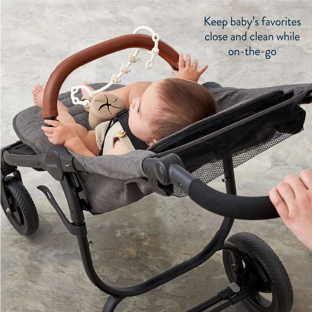 Itzy Ritzy Itzy Strap stroller accessory with brown curved handle and hanging plush teether toys
