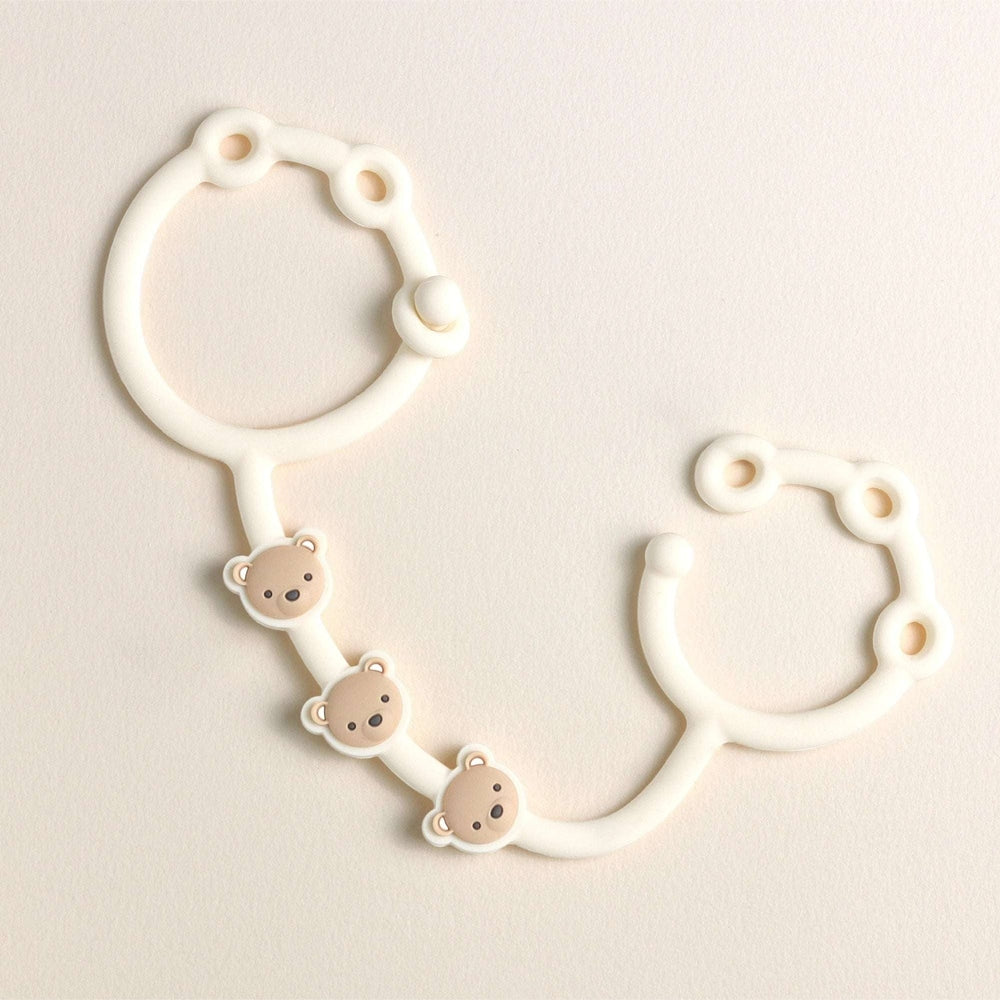 Itzy Ritzy Itzy Strap teething toy holder in white silicone with three beige bear charms