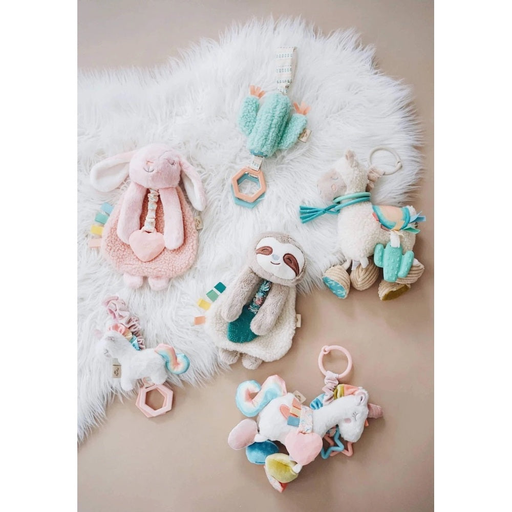 Itzy Ritzy Jingleb Attachable Travel Toy set; pastel plush unicorn and bunny with teether charms