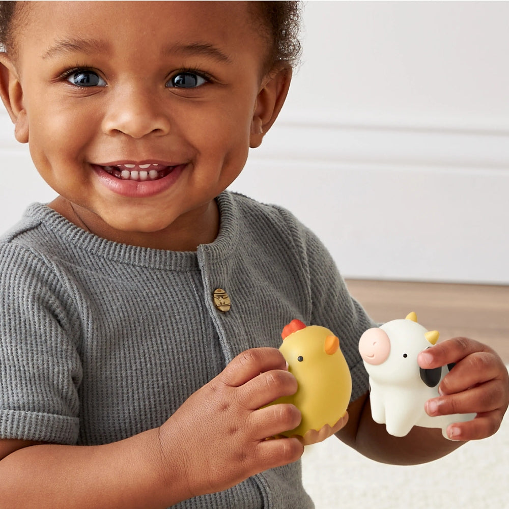 Itzy Ritzy Play Barn Spill and Fill Activity Toy, yellow chick and white cow figures, toddler squeezes them together.