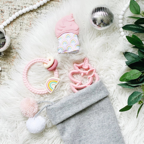 Itzy Ritzy silicone rattle teether; pink unicorn with rainbow ring and gray pouch