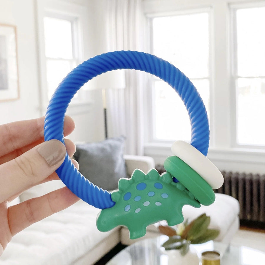Itzy Ritzy silicone teether rattle with blue twisted loop and green dinosaur shape