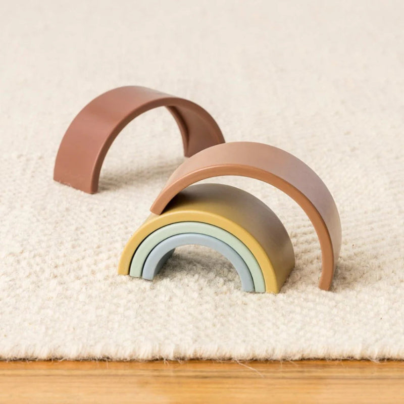 Itzy Ritzy Ritzy Rainbow Stacking Toy, set of pastel rainbow arches on a soft rug