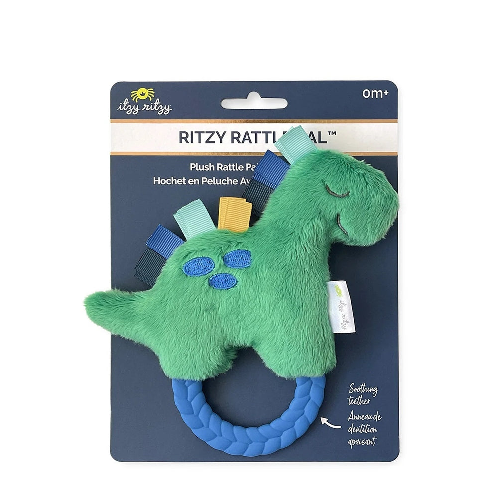 Itzy Ritzy Ritzy Rattle Pal plush dinosaur teether with green fur, blue braided ring, and colorful ribbons