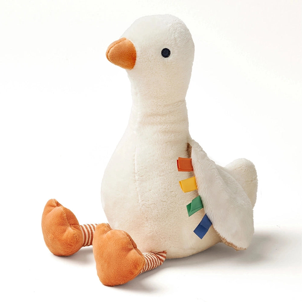 Itzy Ritzy Sweetie Snuggles Plush goose, white plush with orange beak and feet, sits upright with colorful tabs along its wing.