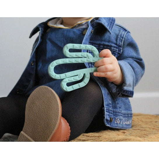 Itzy Ritzy Teething Mitt & Teether Gift Set in mint teal, held by toddler wearing denim.