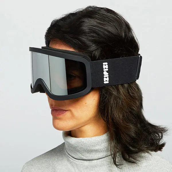 IZIPIZI Snow Cat2-Black ski goggles on a woman, black frame with mirrored lenses and strap logo.