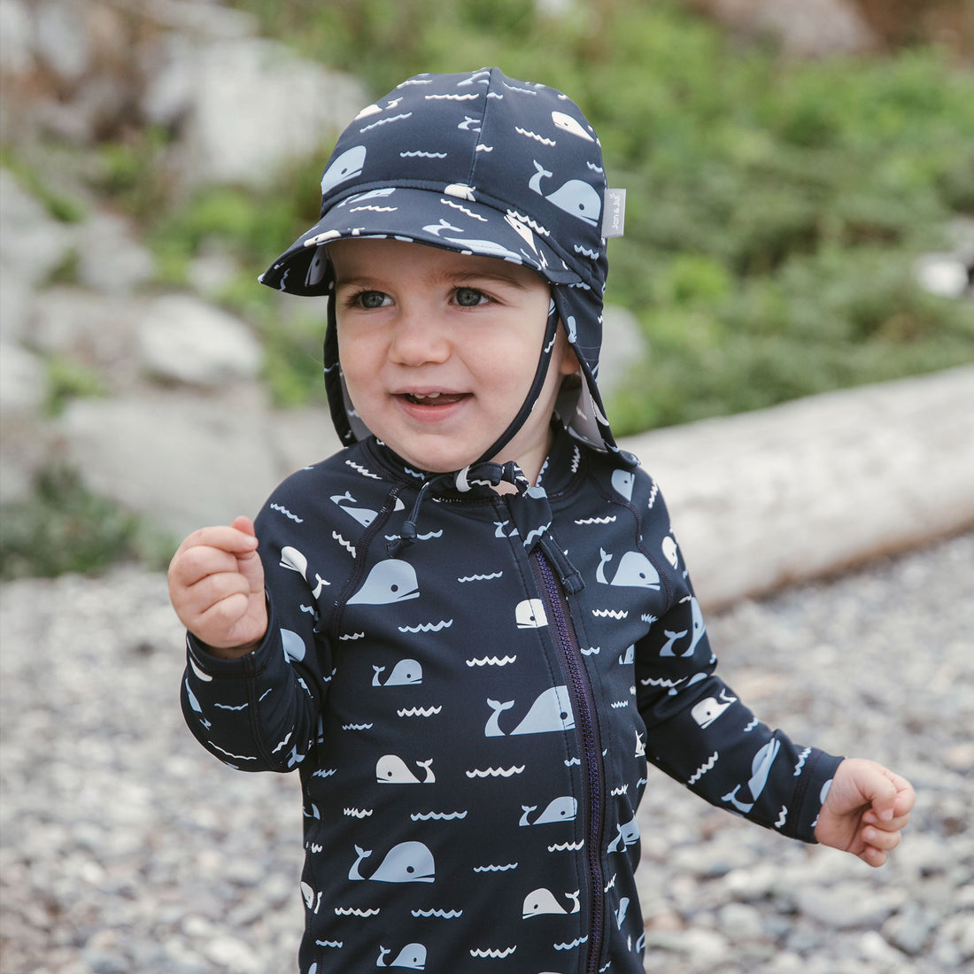 Jan & Jul UV Baby Cap - UV Quick Dry - Navy Whale Tales baby wearing front three-quarter view