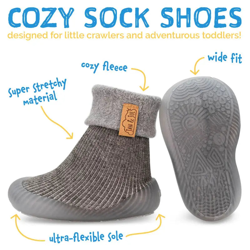 JAN & JUL Cozy Sock Shoes Oat for babies; gray knit sock with fleece cuff and ultra-flexible sole shown on a toddler.