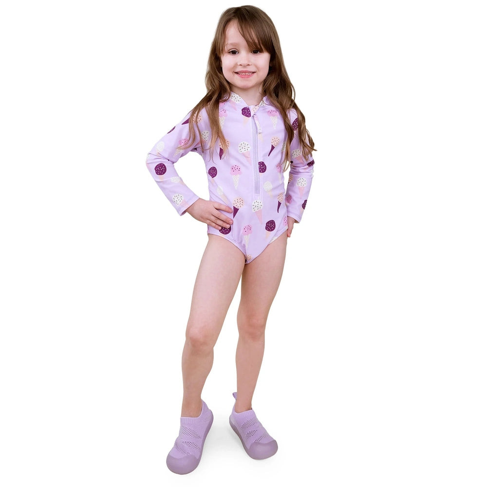 Jan & Jul Girls One Piece UV Swimsuit Lavender Ice Cream worn by smiling toddler in lavender long-sleeve, ice-cream print.